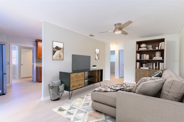 living room with light hardwood / wood-style flooring and ceiling fan