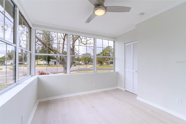 unfurnished sunroom with ceiling fan