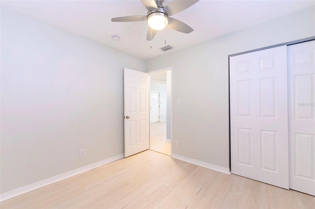 unfurnished bedroom with ceiling fan, light hardwood / wood-style floors, and a closet