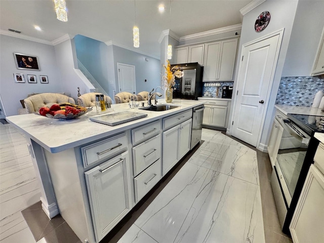 kitchen with a kitchen island with sink, sink, hanging light fixtures, decorative backsplash, and stainless steel appliances