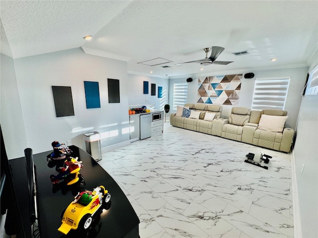 living room featuring a textured ceiling, ceiling fan, and ornamental molding