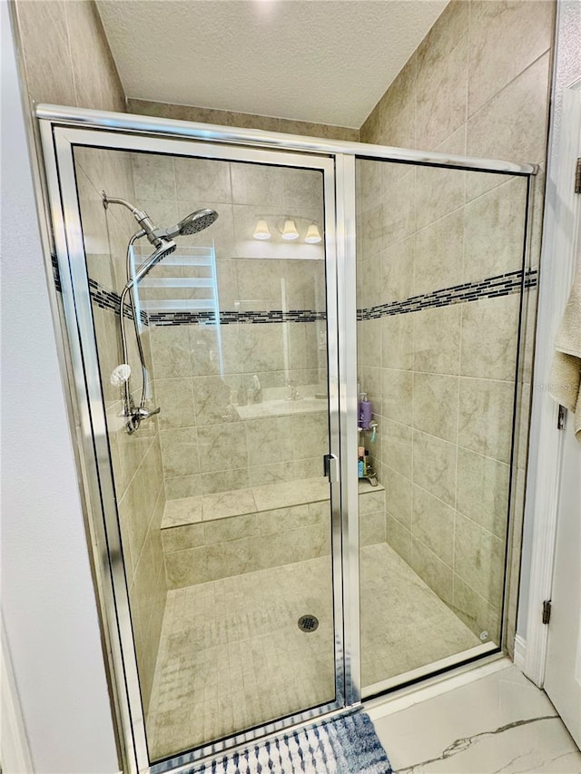 bathroom featuring a textured ceiling and an enclosed shower