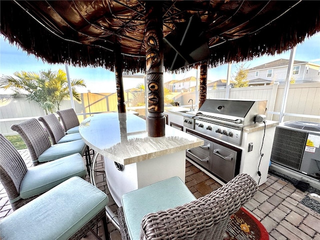 view of patio with a grill, area for grilling, an outdoor wet bar, and central AC