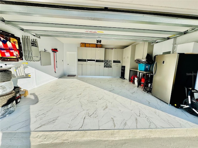 garage featuring electric panel and stainless steel fridge