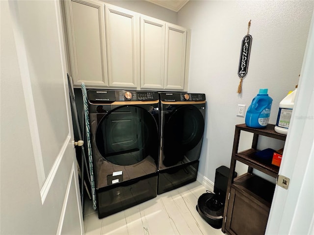 laundry room featuring washing machine and clothes dryer and cabinets