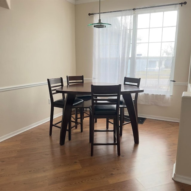 dining room with crown molding and hardwood / wood-style floors