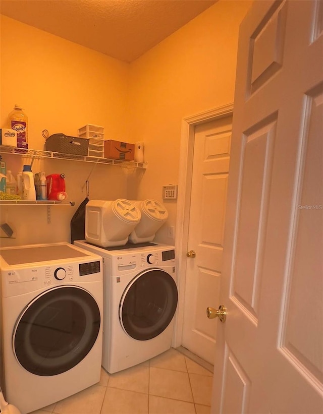 laundry area featuring washer and clothes dryer and light tile patterned flooring