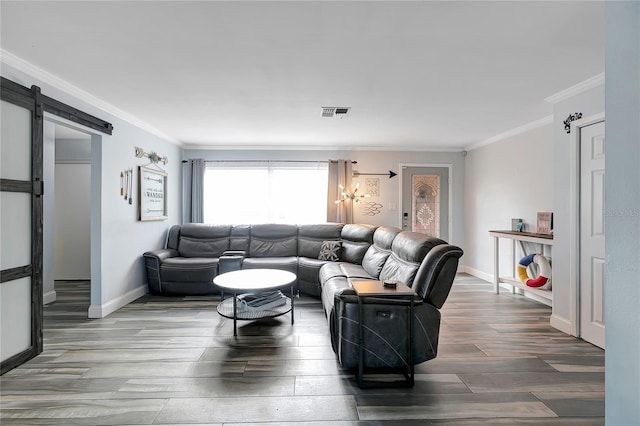 living room featuring a barn door, hardwood / wood-style floors, and ornamental molding