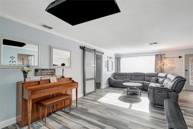 living room featuring a barn door, light hardwood / wood-style floors, and crown molding