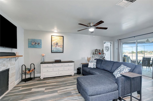 living room featuring a fireplace, dark hardwood / wood-style floors, and ceiling fan