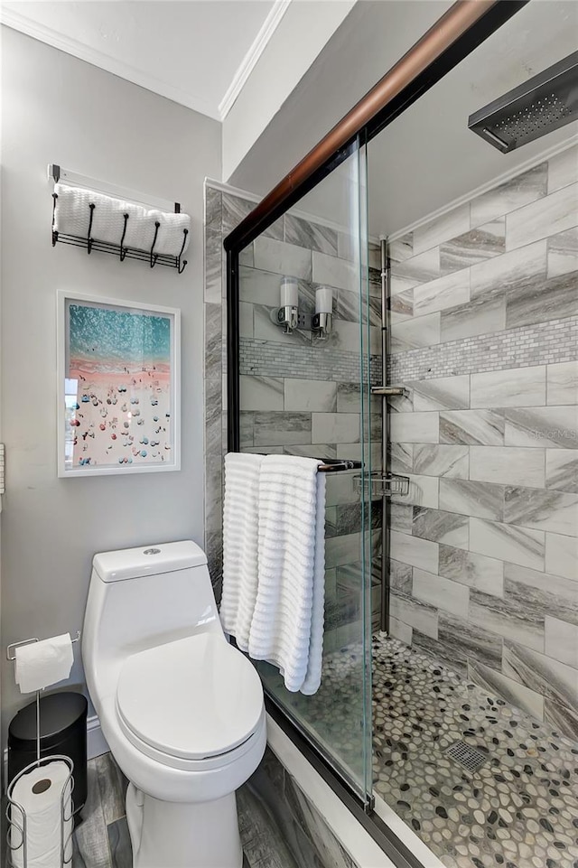 bathroom with hardwood / wood-style floors, toilet, crown molding, and an enclosed shower