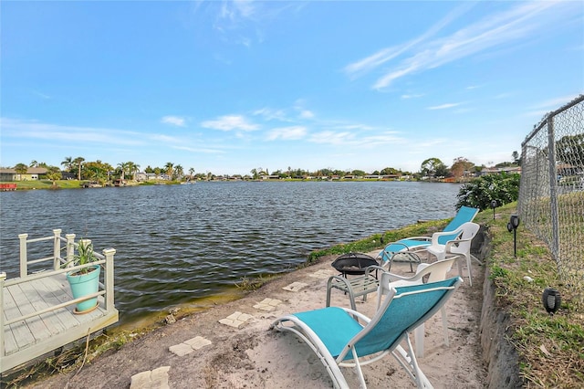 dock area with a water view and an outdoor fire pit