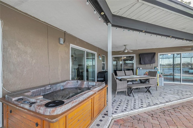 view of patio with ceiling fan and a hot tub