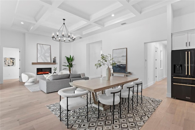 dining area featuring beamed ceiling, light hardwood / wood-style flooring, and coffered ceiling