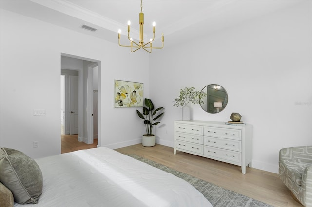 bedroom with a chandelier and light hardwood / wood-style floors