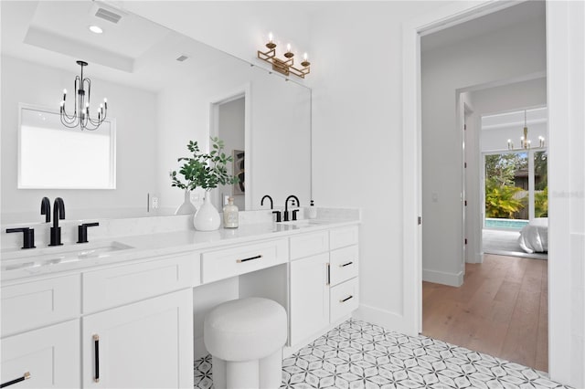 bathroom with hardwood / wood-style floors, vanity, and a raised ceiling