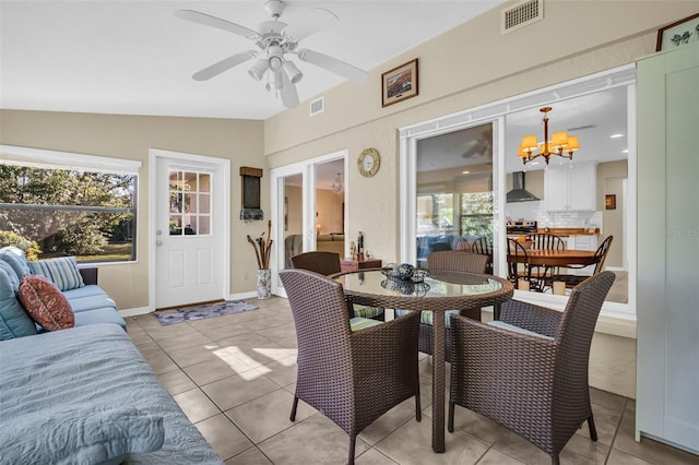 interior space featuring lofted ceiling, ceiling fan with notable chandelier, and a wealth of natural light