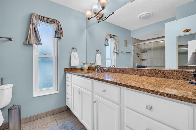 bathroom with walk in shower, tile patterned floors, toilet, vanity, and a notable chandelier