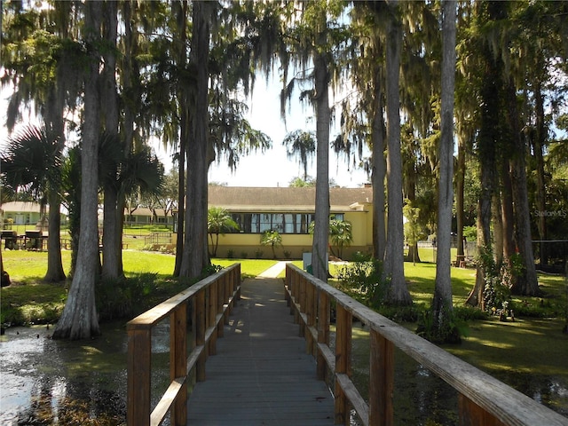 view of dock featuring a water view and a lawn