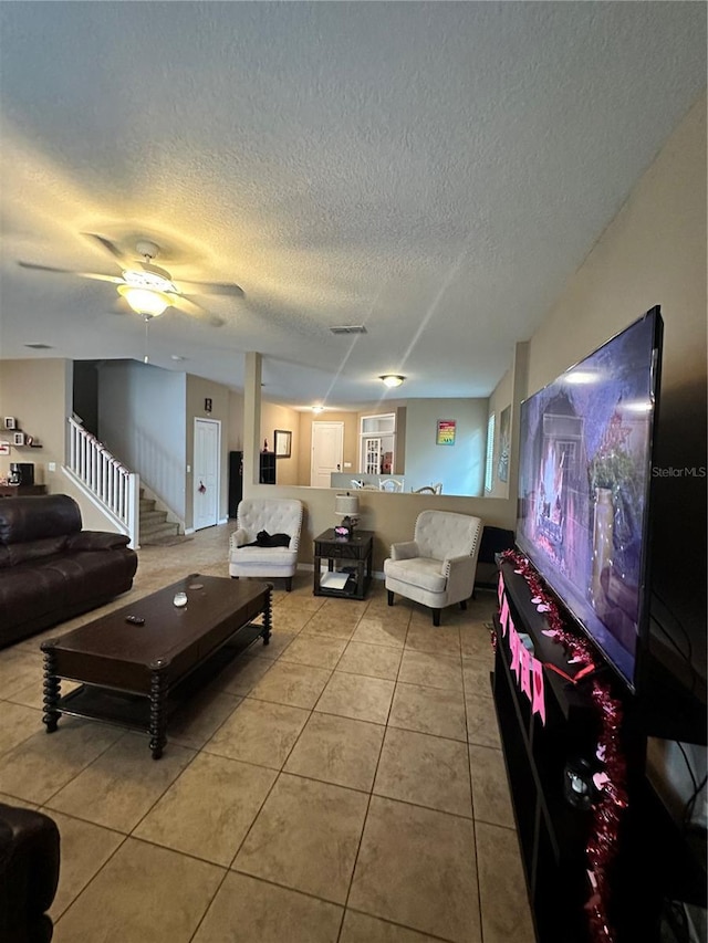 living room featuring ceiling fan and light tile patterned flooring