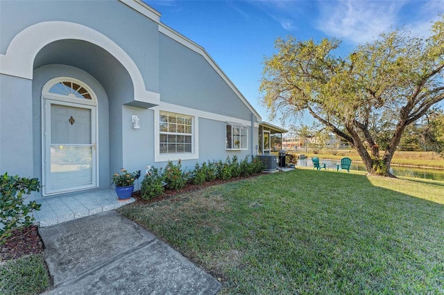 property entrance featuring central AC and a yard