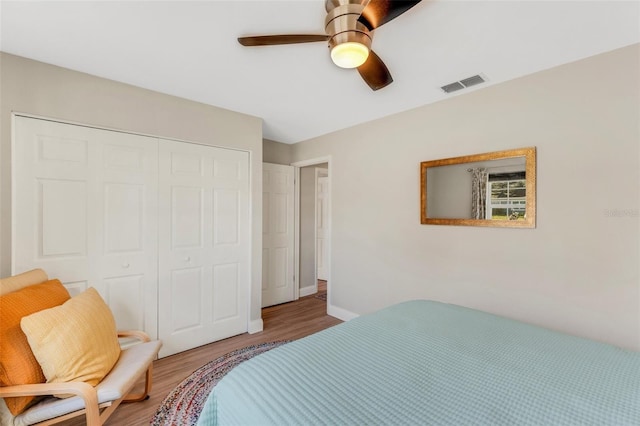 bedroom with hardwood / wood-style floors, ceiling fan, and a closet