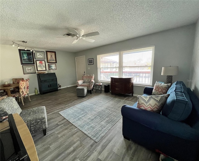 living room with hardwood / wood-style flooring, ceiling fan, and a textured ceiling