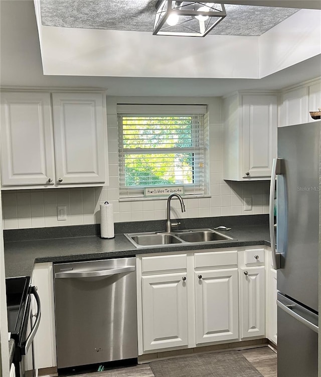 kitchen with sink, white cabinets, dark hardwood / wood-style floors, and appliances with stainless steel finishes