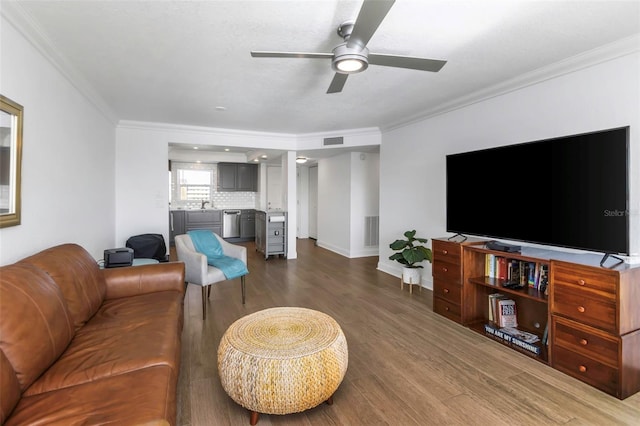 living room with sink, dark hardwood / wood-style flooring, and ornamental molding