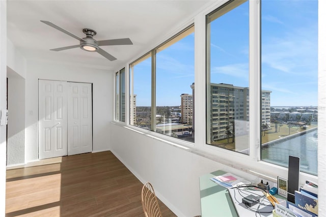 unfurnished sunroom with ceiling fan