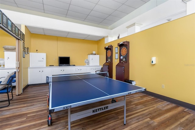 rec room with a paneled ceiling and dark hardwood / wood-style floors