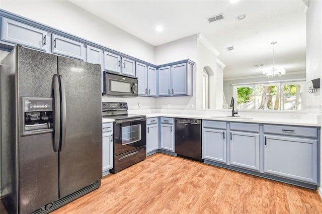 kitchen featuring crown molding, sink, black appliances, an inviting chandelier, and light hardwood / wood-style floors