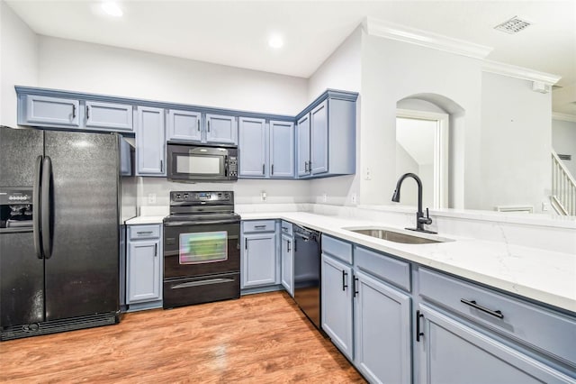 kitchen featuring black appliances, crown molding, sink, light stone countertops, and light hardwood / wood-style floors