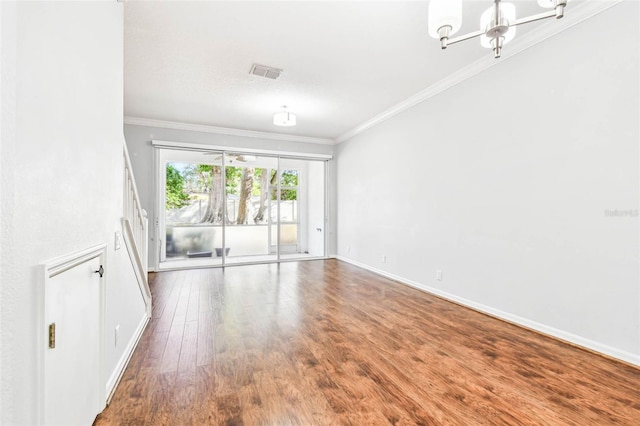 empty room featuring hardwood / wood-style floors, an inviting chandelier, and ornamental molding