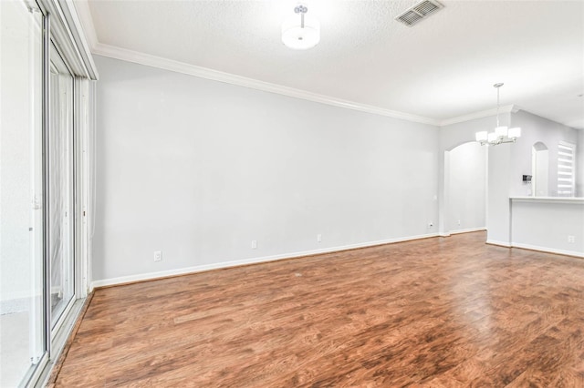 unfurnished living room featuring hardwood / wood-style floors, a chandelier, a textured ceiling, and ornamental molding