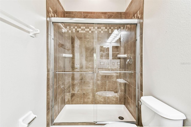 bathroom featuring an enclosed shower and toilet