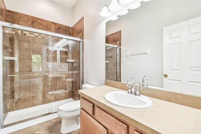 bathroom featuring tile patterned flooring, vanity, toilet, and walk in shower