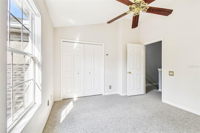 unfurnished bedroom featuring ceiling fan, a closet, carpet floors, and vaulted ceiling