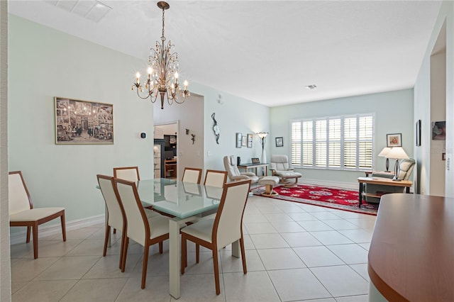 dining area with light tile patterned flooring and an inviting chandelier