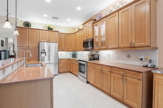 kitchen featuring decorative backsplash, sink, stainless steel appliances, and hanging light fixtures