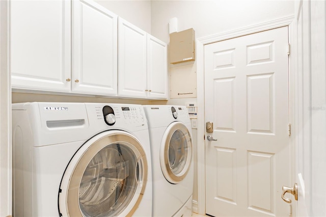 laundry area featuring washing machine and dryer and cabinets