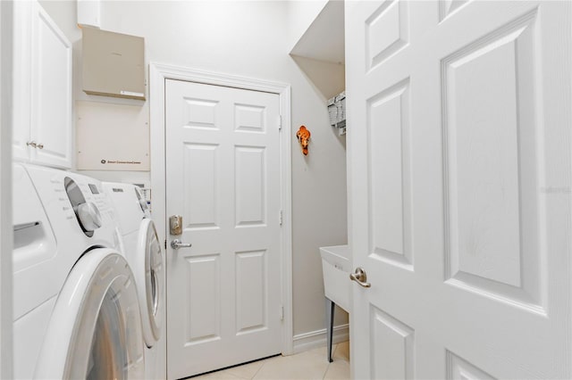 laundry room featuring cabinets, independent washer and dryer, and light tile patterned floors