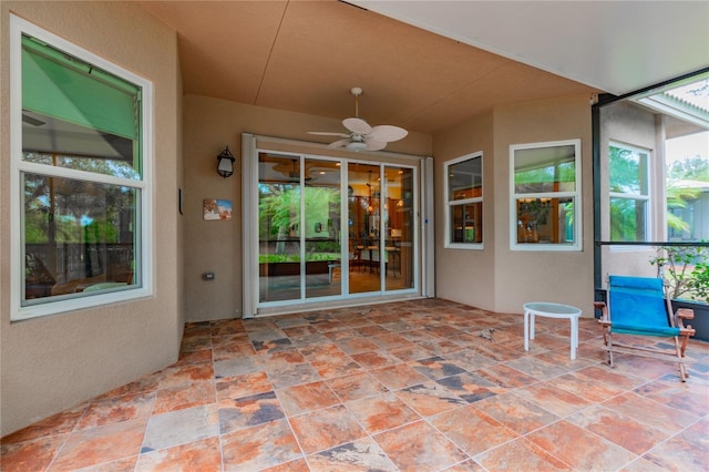 unfurnished sunroom featuring ceiling fan