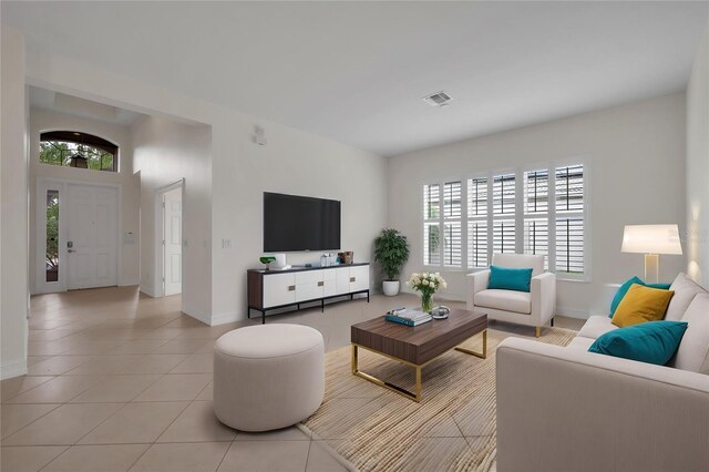 living area with a healthy amount of sunlight, light tile patterned floors, baseboards, and visible vents