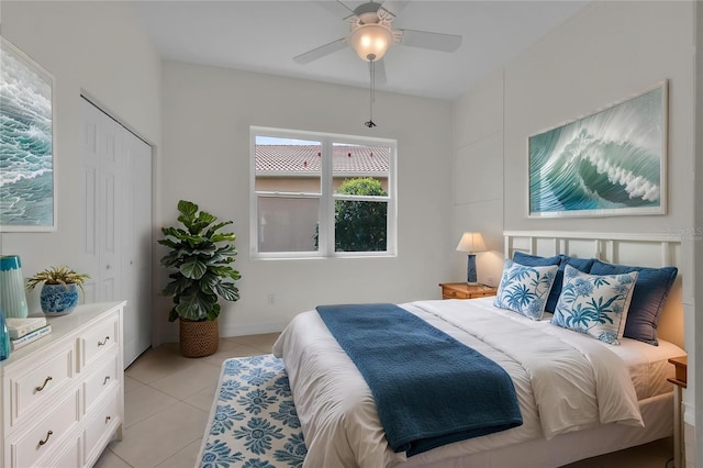 bedroom featuring a closet, a ceiling fan, and light tile patterned floors