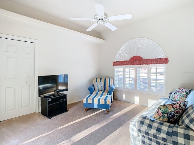 sitting room with ceiling fan and carpet