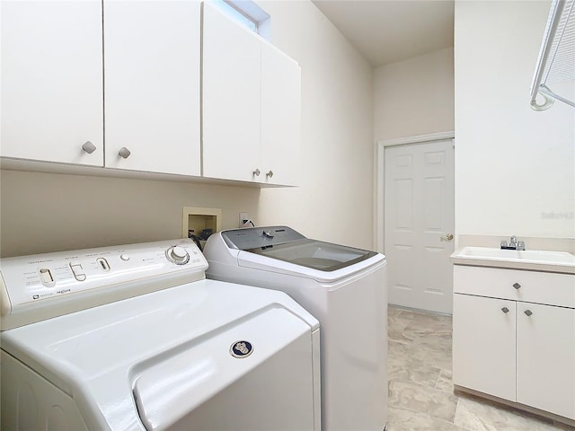 laundry area with washer and dryer, sink, and cabinets