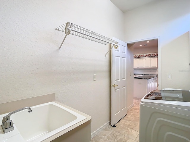 clothes washing area featuring laundry area, independent washer and dryer, and baseboards