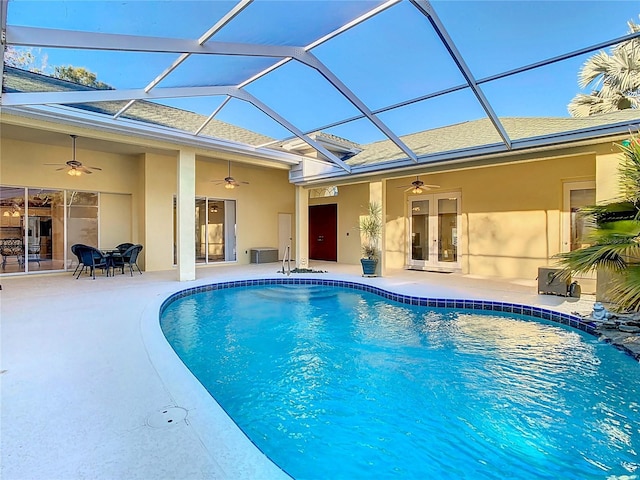 view of swimming pool featuring glass enclosure, ceiling fan, french doors, and a patio