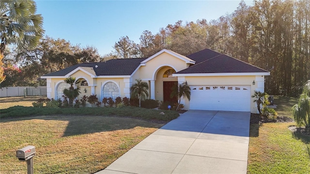 ranch-style house featuring stucco siding, a front lawn, driveway, fence, and an attached garage